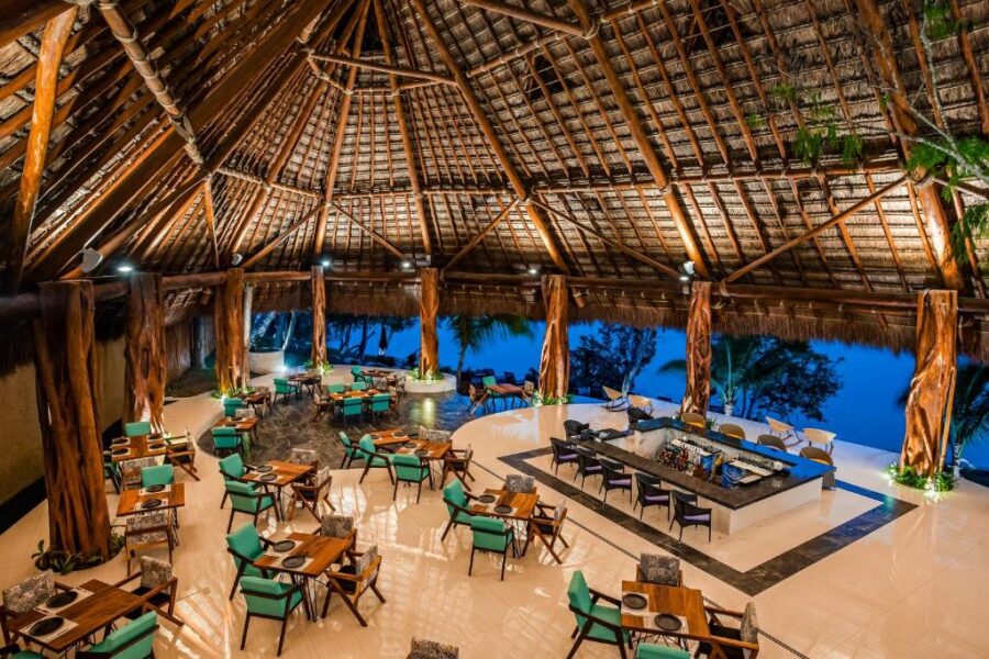 The Mia Bacalar Luxury Resort & Spa restaurant features a spacious dining area with a large, elegant roof overhead.