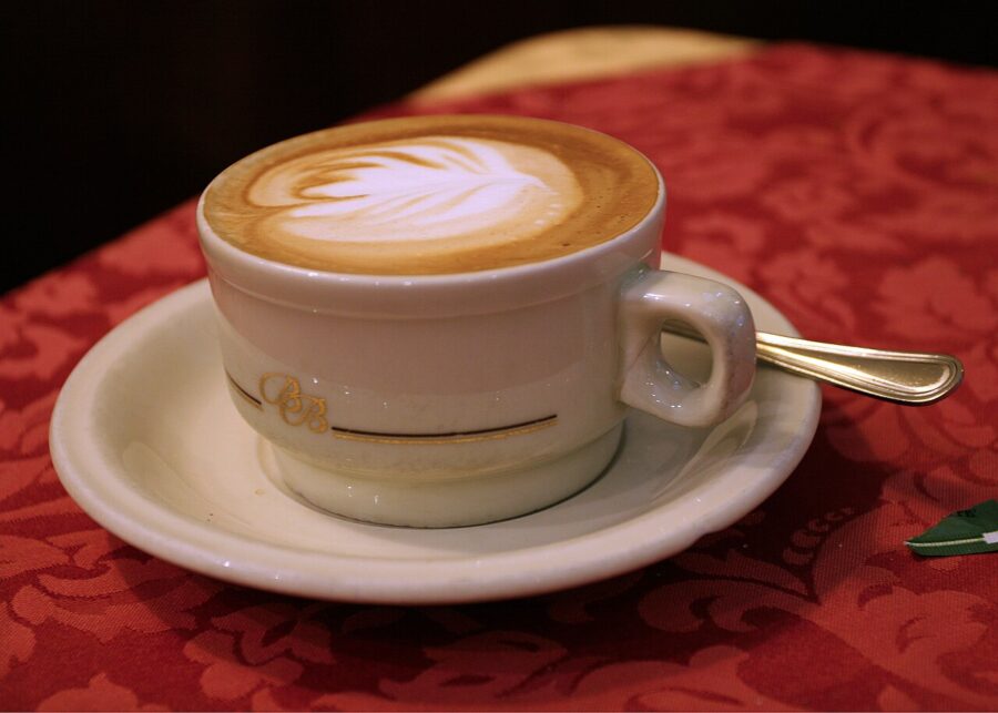 Cup of cappuccino on a saucer, showcasing the rich coffee culture of Milan, Italy.