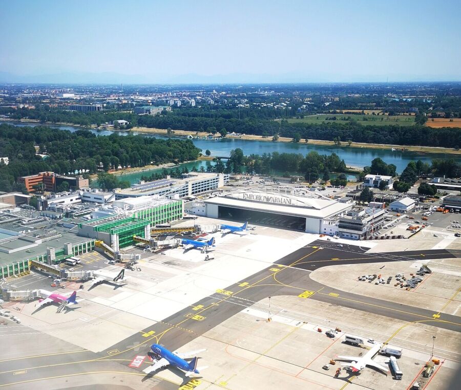 Aerial view of Milan Linate Airport featuring several airplanes parked on the tarmac.
