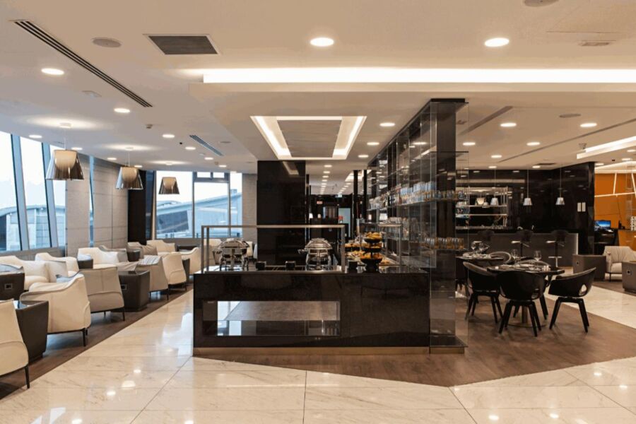 Interior of Milan Malpensa Lounge featuring tables and chairs arranged for dining.
