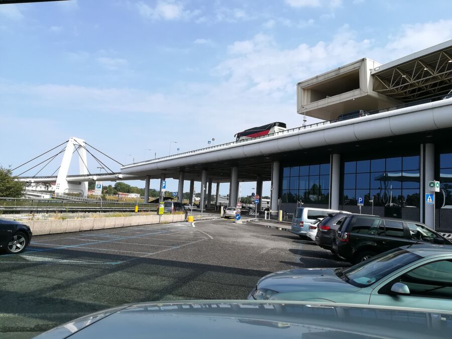 White bridge at Milano Malpensa Airport, Italy, connecting different terminals with a modern architectural design.