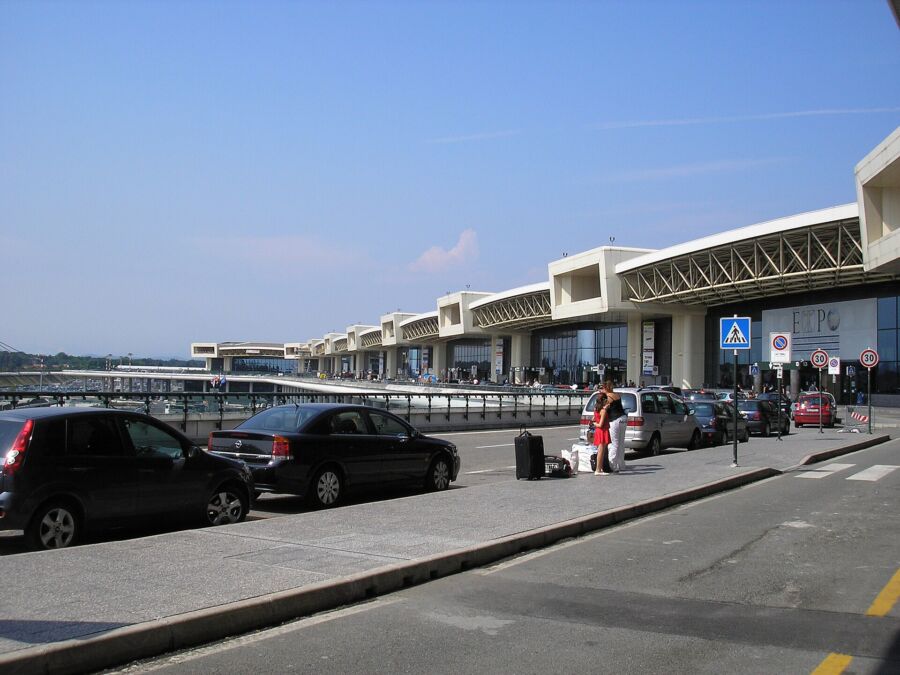 Milano Malpensa Airport's parking lot featuring multiple cars parked in designated spaces.