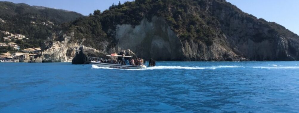 Boat is anchored in the clear blue waters beside a cliff on Milos Island, highlighting the scenic coastal landscape.