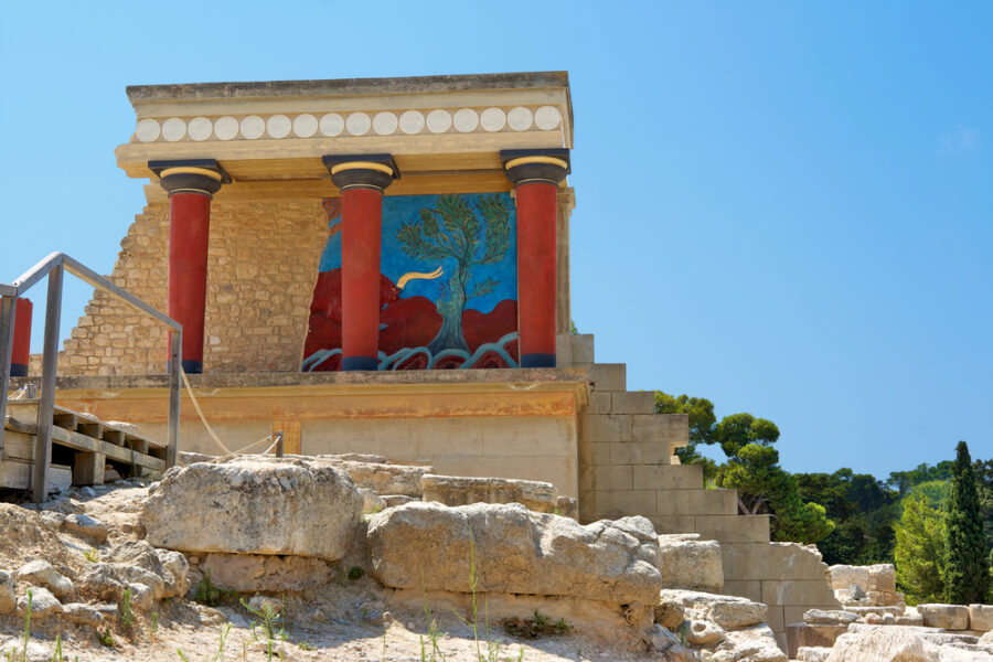 Ancient Minoan Knossos palace with red columns, frescoes, showcasing early advanced European civilization.