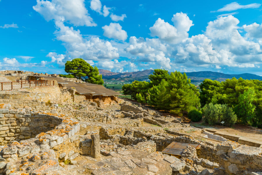 Panoramic view of the ancient Minoan Palace of Phaistos ruins, showcasing a stone road on Crete's Messara plateau.