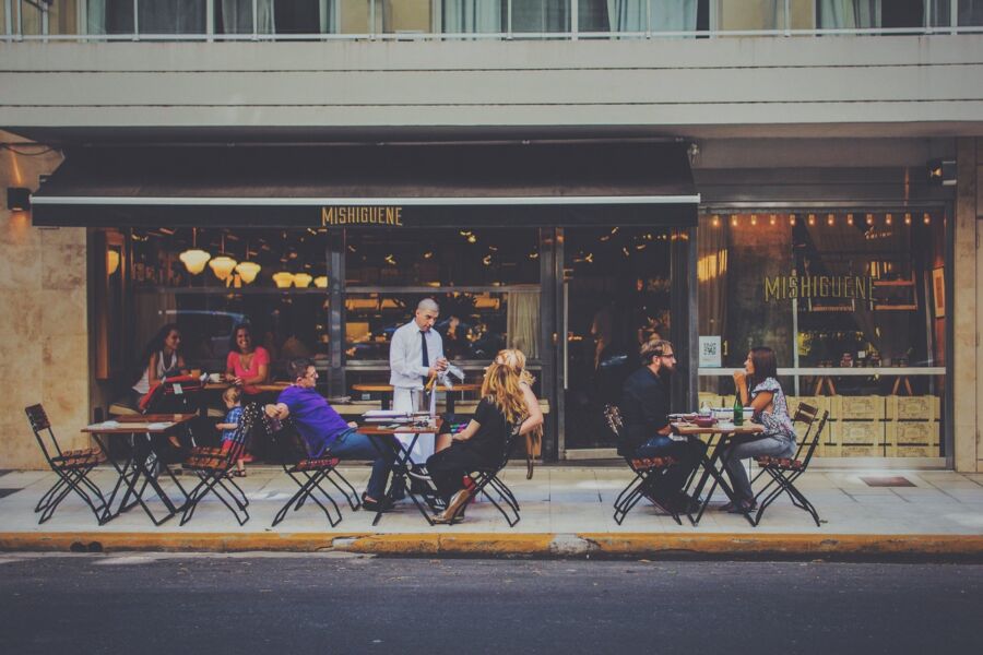 Outdoor dining at Mishiguene: lively bistro ambiance, engaging conversations, professional service.