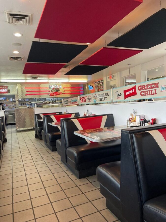 Moab Diner interior featuring black and red booths with vibrant red and white walls, creating a lively atmosphere.
