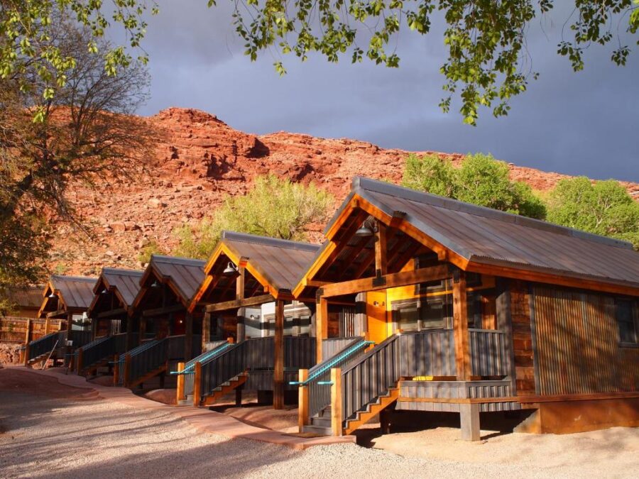 Moab Springs Ranch, Utah, multiple cabins are arranged in front of a majestic mountain, offering a serene getaway.

