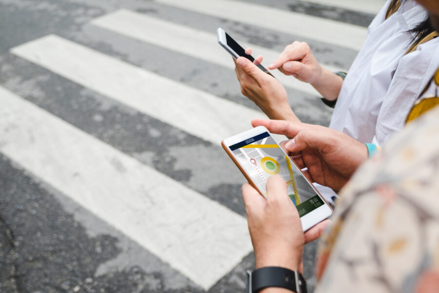 Traveler using a mobile app to navigate city streets with GPS, highlighting technology's role in modern travel.