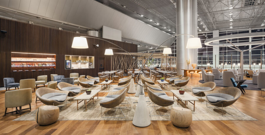 Modern airport lounge with stylish seating, wood accents, and elegant lighting.
