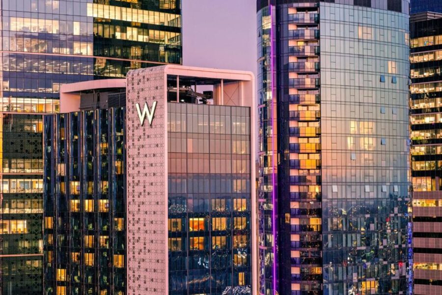 Modern Brisbane hotel skyscrapers at dusk with W Brisbane tower, glass facades and city lights.