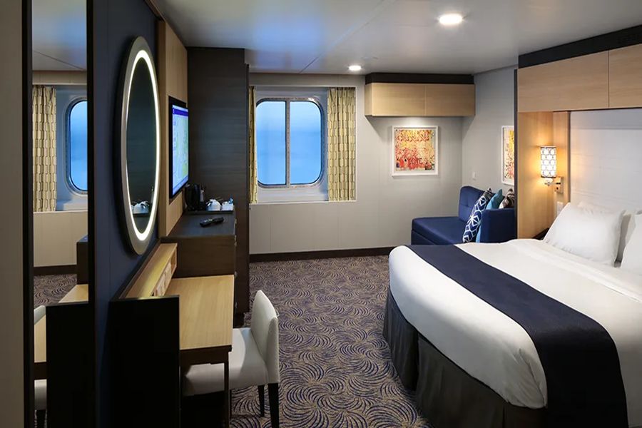 Modern cruise cabin with ocean view, elegant design, and cozy ambiance.
