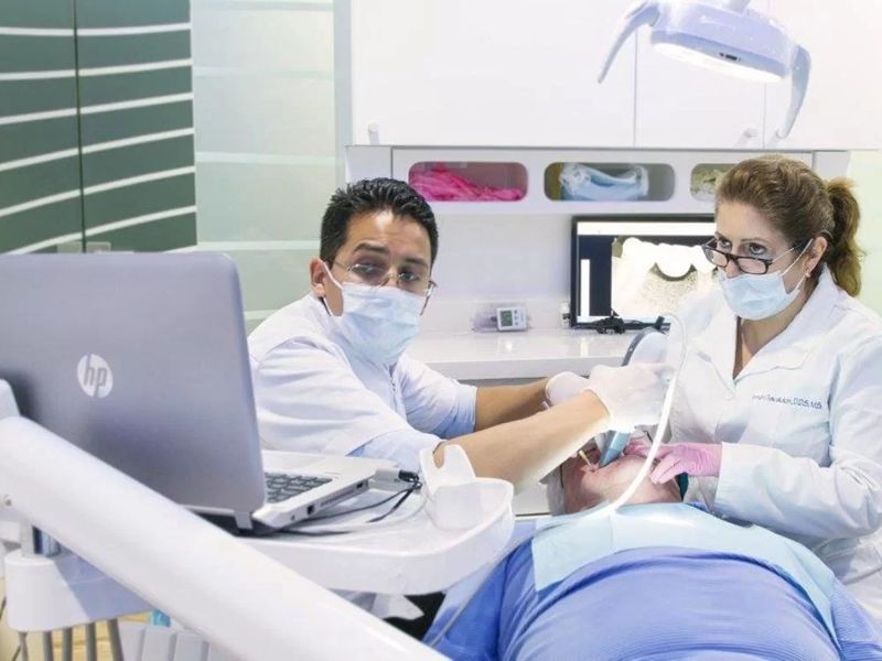 Modern dental clinic with dentist and assistant caring for patient.
