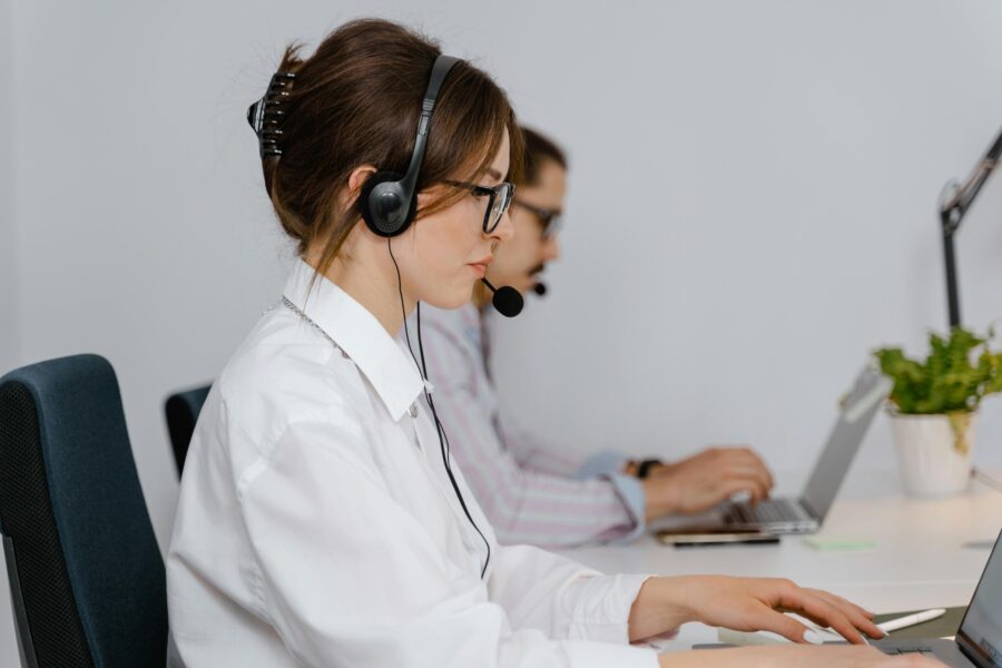 Modern office with professionals using laptops and headsets in a sleek, organized workspace.