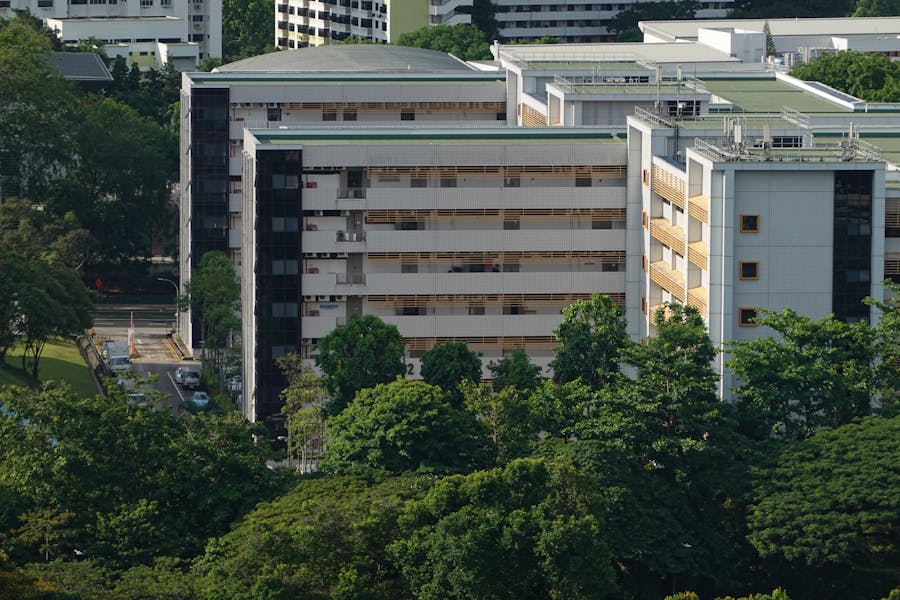 Modern residential complex with contemporary architecture, large windows, lush greenery, and urban harmony.