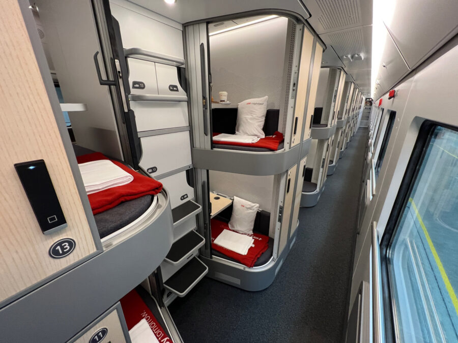 Modern train compartment with sleek sleeping pods and privacy features for comfortable travel.