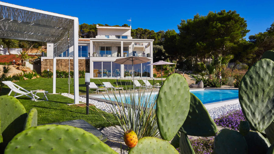 Modern villa with pool, lush landscape, sleek design, and inviting outdoor space.