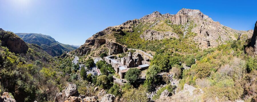 Monastery of Geghard in Armenia, featuring ancient stone architecture and lush surrounding landscapes.
