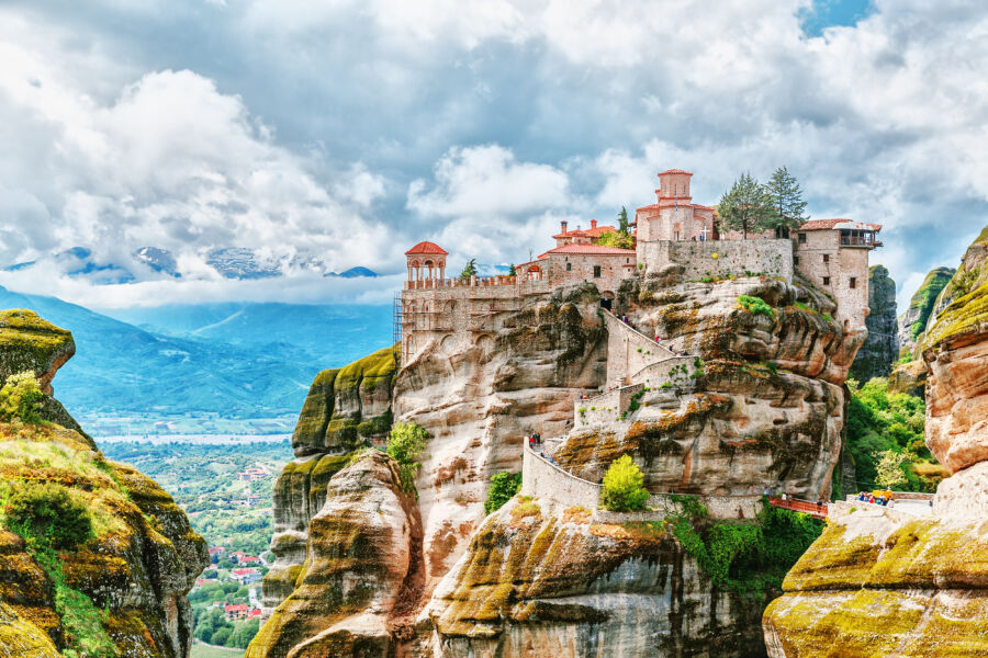 The Meteora Monasteries in Greece, dramatically situated on high cliffs, showcasing their unique architecture against a blue sky.
