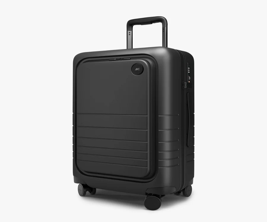 Monos Carry-On Pro Side suitcase in black, featuring wheels, set against a white background.