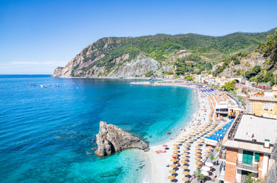 Scenic beach at Monterosso al Mare, featuring golden sand and clear blue waters, surrounded by colorful coastal buildings
