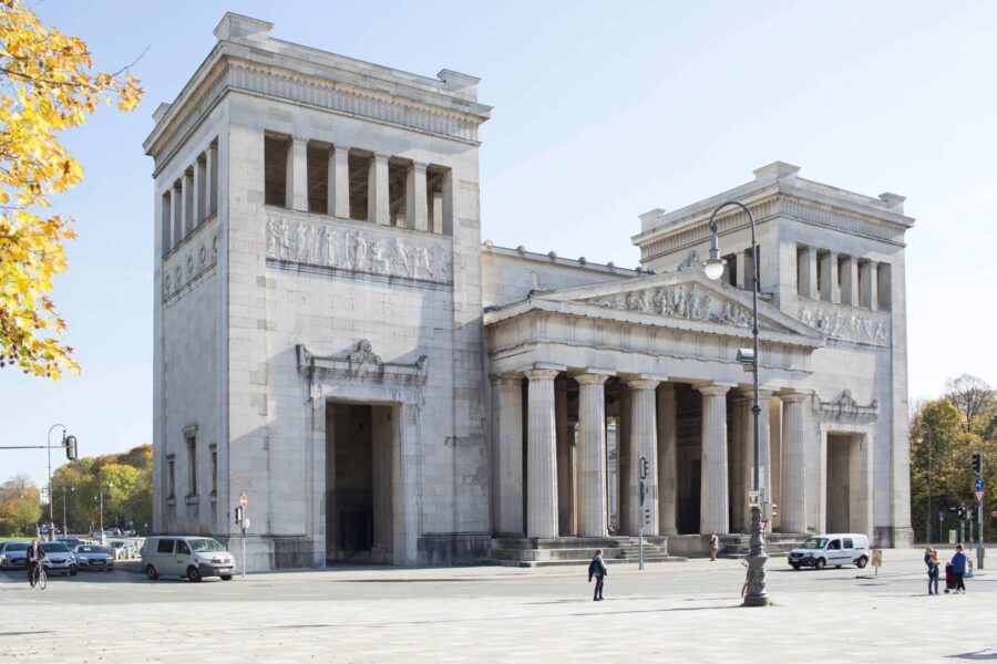 Neoclassical stone monumental temple-like facade with Doric columns and urban plaza.
