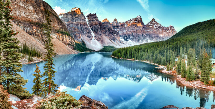 Panoramic view of Moraine Lake surrounded by mountains in Banff National Park, Alberta, Canada, showcasing vibrant blue waters.
