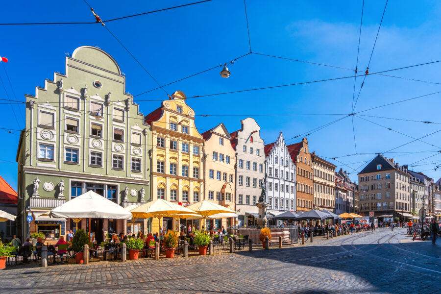 Panoramic view of Moritzplatz in Augsburg, Bayern, showcasing historic buildings and vibrant city life.