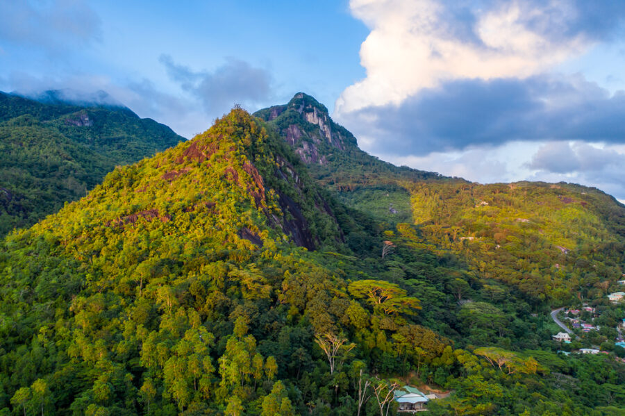 Aerial sunset view of Morne Seychellois National Park rainforest mountains on Mahé Island, Seychelles.