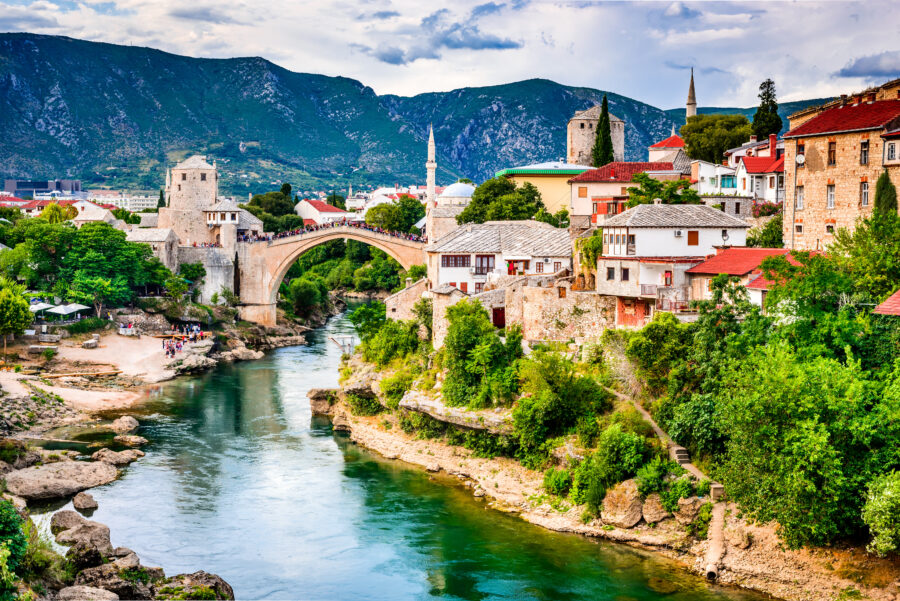 Scenic view of Mostar's Old Town, showcasing traditional buildings and the famous Stari Most bridge spanning the river.
