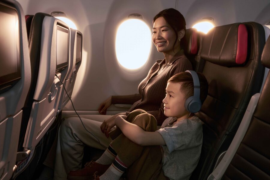 Mother and son enjoying a comfortable flight next to airplane window.