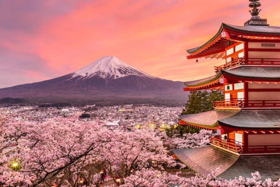 Mount Fuji sunset with cherry blossoms and traditional pagoda in a serene Japanese landscape.