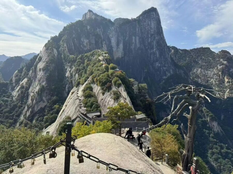 The summit of Mount Hua in China, showcasing rugged peaks and a clear blue sky.
