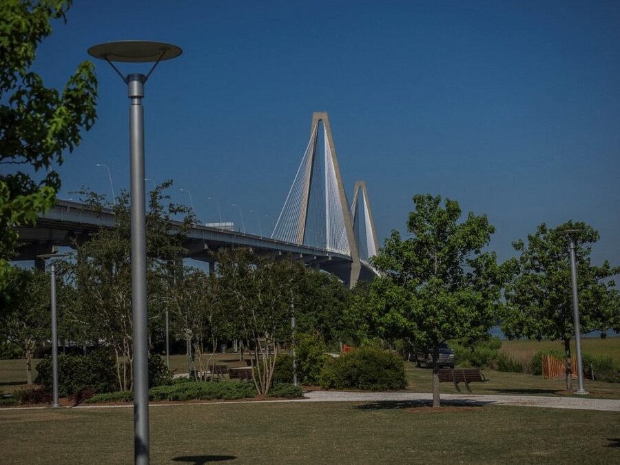 Mount Pleasant Memorial Waterfront Park showcasing a bridge in the background, surrounded by trees and open space.
