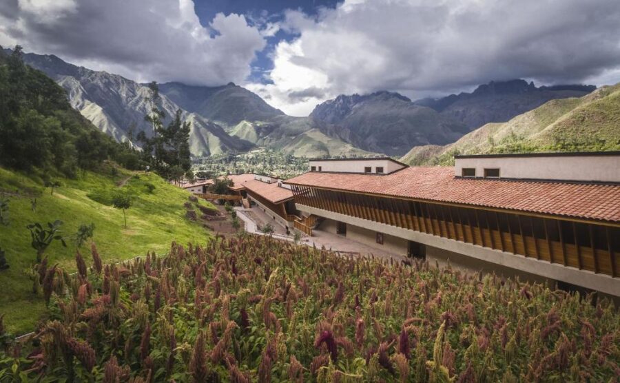 Modern hillside resort in Peru’s Sacred Valley with mountain views, dramatic clouds, and wildflower garden.