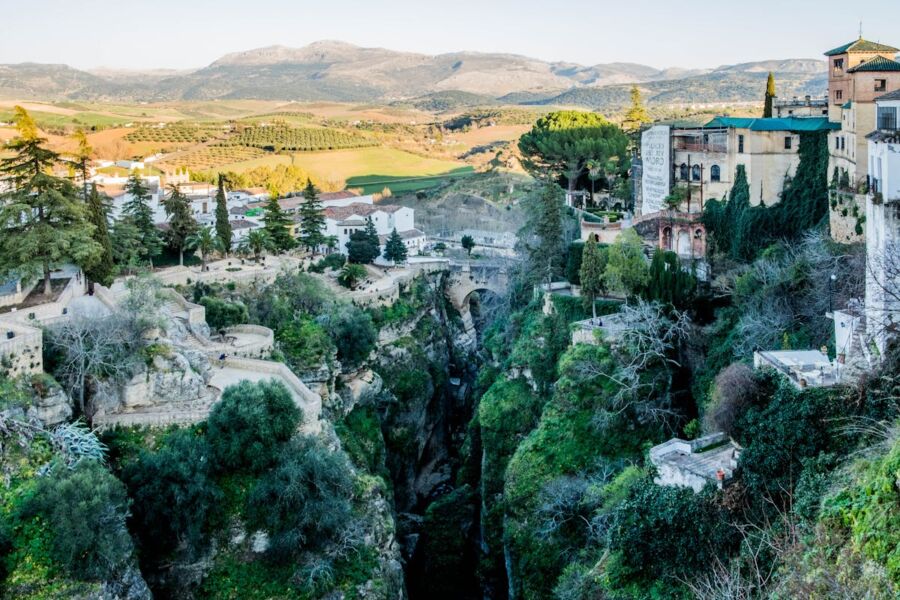 Panoramic view of Southern Spain gorge, village, and olive groves at sunset.