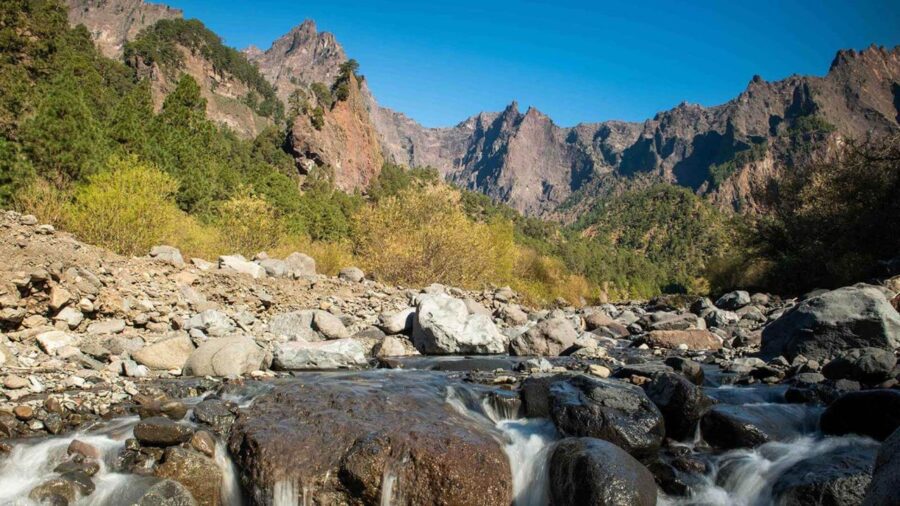 Caldera de Taburiente National Park mountain stream with boulders and jagged peaks.