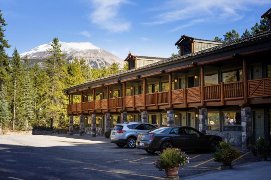 Mountaineer Lodge in Canada, showcasing a rustic exterior surrounded by scenic mountain views and lush greenery.