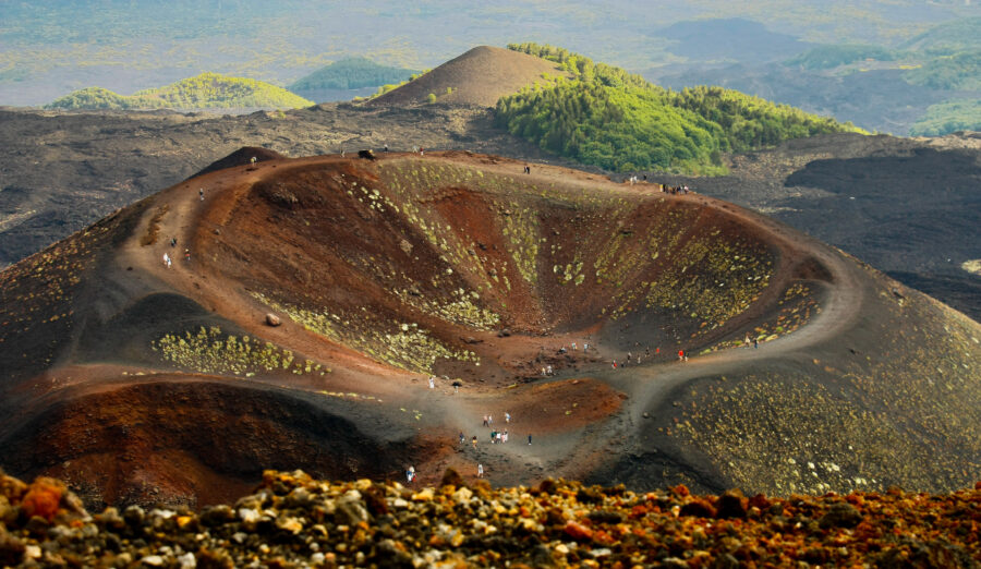 Mount Etna, an active volcano in Sicily, Italy, rises majestically against a clear blue sky