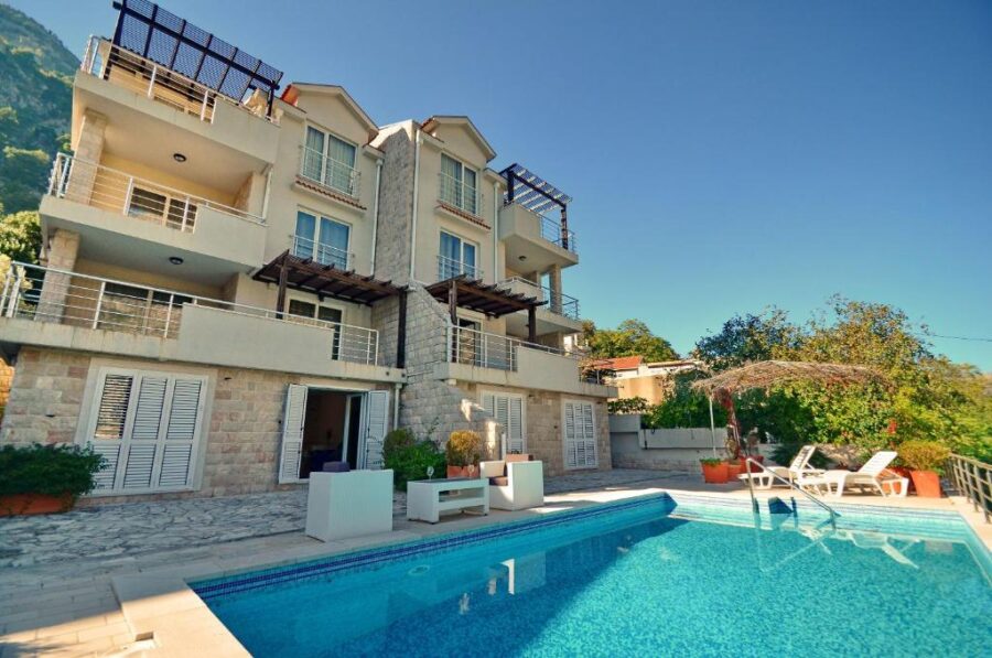 Muo Apartments in Kotor, showcasing a spacious house with a swimming pool and a balcony.