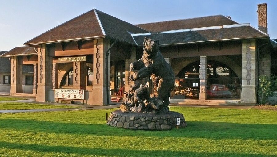Prominent stone bear statue is displayed outside the Museum of the Yellowstone, highlighting the museum's natural themes.