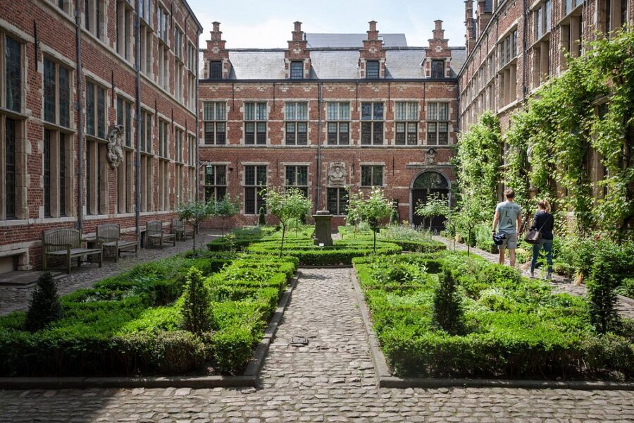 Courtyard garden of the Museum Plantin-Moretus in Antwerp, Belgium, featuring lush greenery and historic architecture.