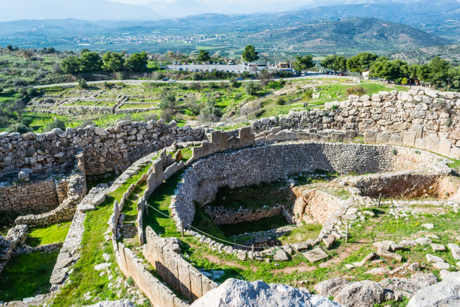 Ancient Mycenae ruins in Greece showcase Cyclopean architecture and lush landscape contrast.