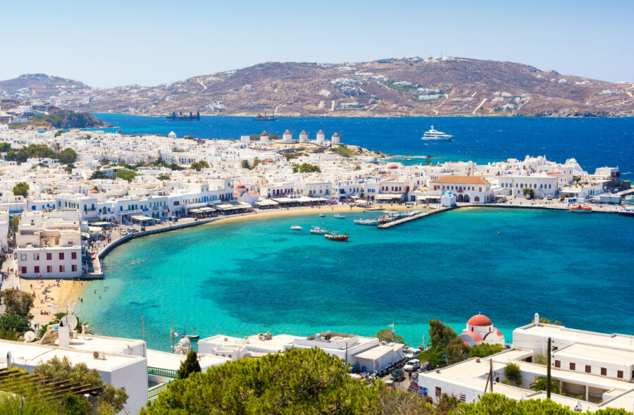 Panoramic view of Mykonos island, featuring iconic white architecture against the vibrant blue sea in the Cyclades, Greece