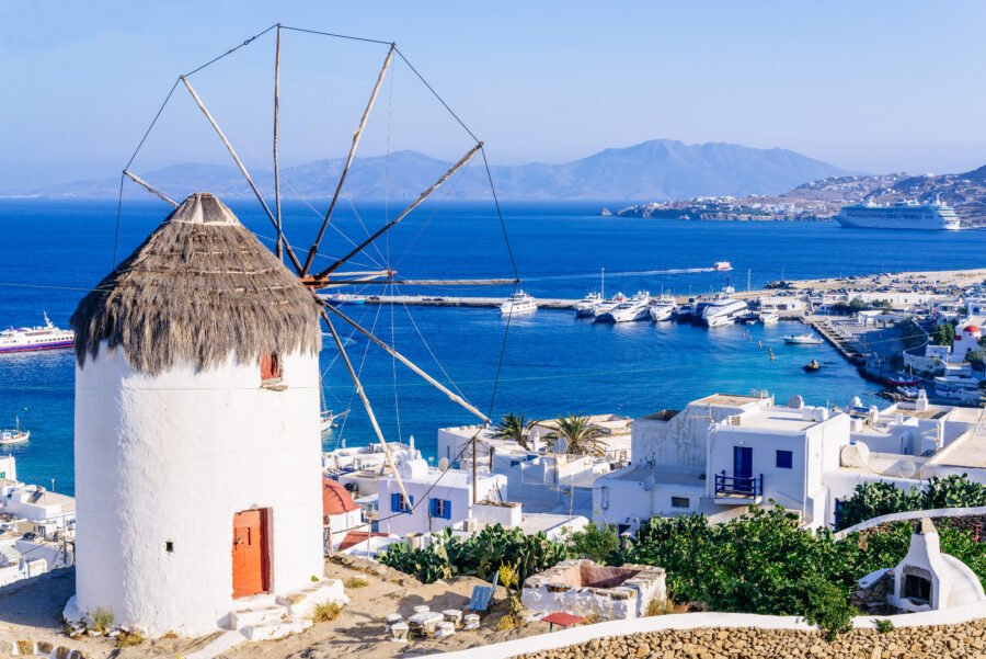 Aerial view of Mykonos island showcasing the iconic windmill and vibrant coastal scenery in the Cyclades, Greece