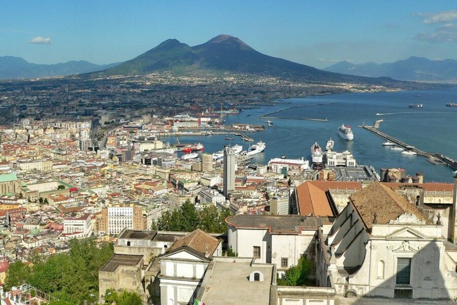 Aerial view of Vomero, Naples: cityscape, Mount Vesuvius, Mediterranean Sea, and vibrant harbor.