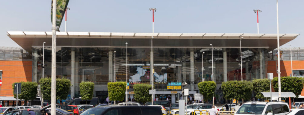 Exterior view of Naples Airport building, showcasing modern architecture against a clear blue sky.