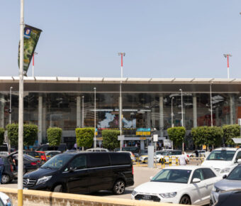 Exterior view of Naples Airport building, showcasing modern architecture against a clear blue sky.