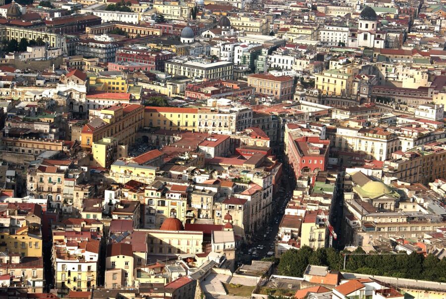 Aerial view of Naples cityscape with historic and contemporary Mediterranean architecture.