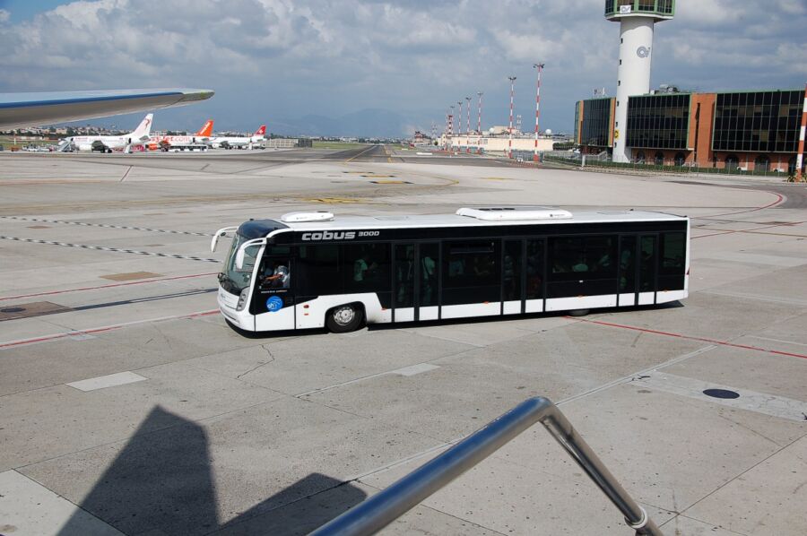 Parked bus on the tarmac at Naples International Airport, awaiting passengers for their flight.